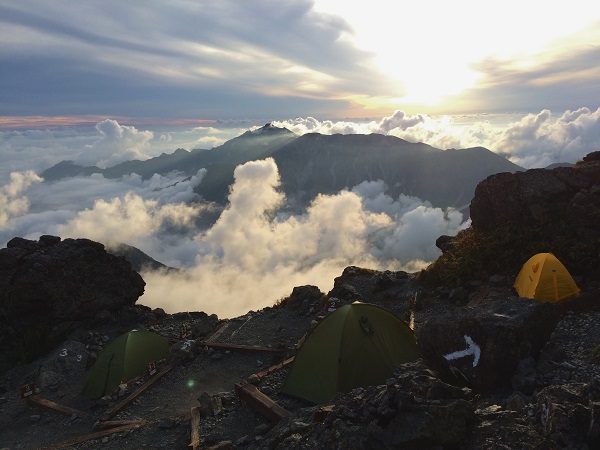 夕暮れの幕営地。夕日に照らされるテントと山々が幻想的でした。